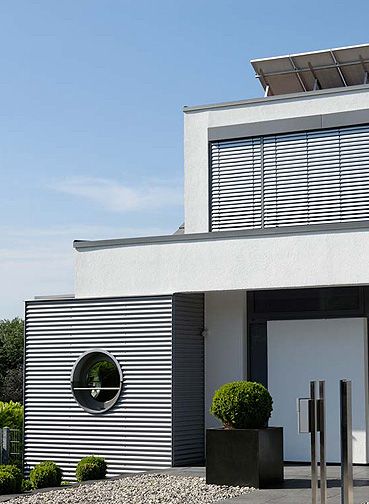 Ein modernes weißes Haus mit Außenrollläden