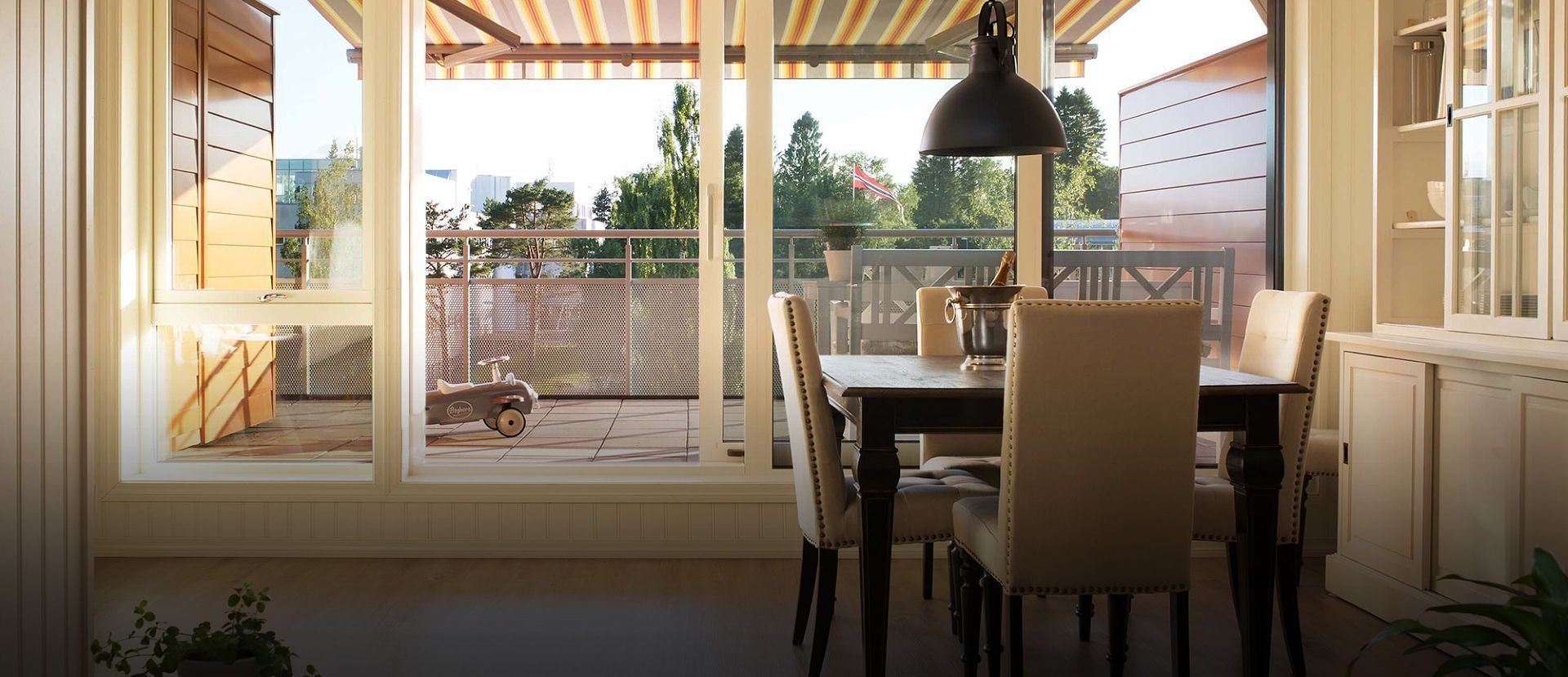 Ein Tisch mit Stühlen steht vor einer großen Fensterfront